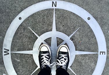 Compass on ground with feet in the middle